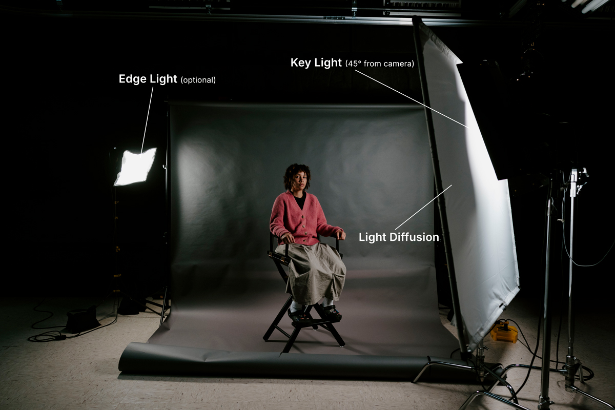 a student posing in an interview setup with dramatic lighting