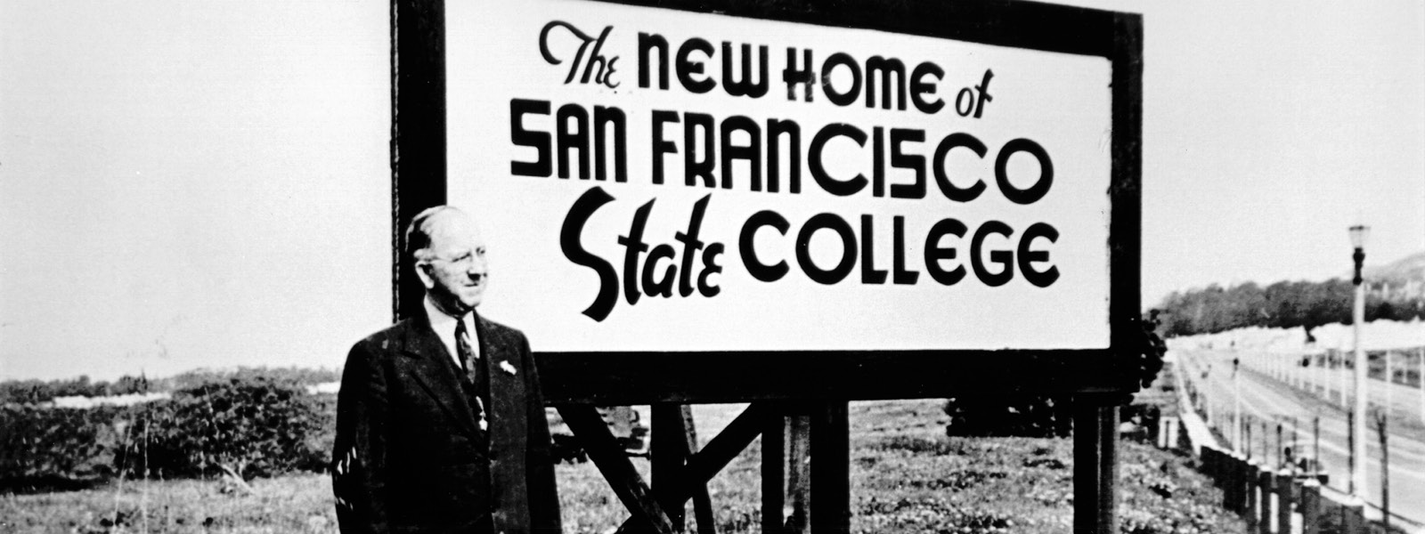 historic photo with a sign that reads 'The New Home of SF State College"